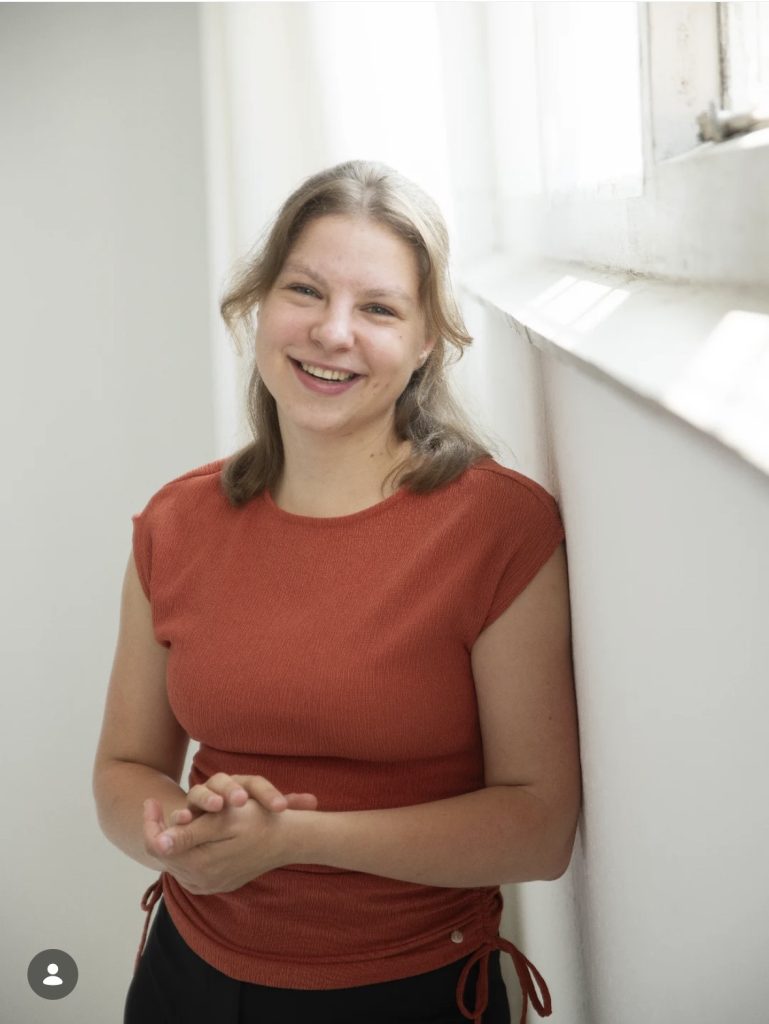 Portret van Femke Pijnappel, dansdocent bij Balletstudio Danielle, staand bij een raam